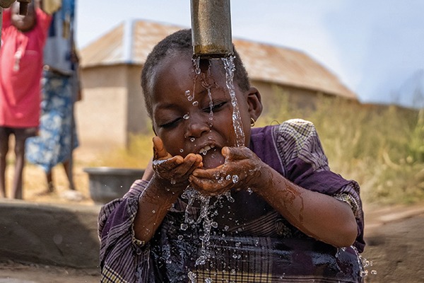 Aziza drinking clean, safe water from a borehole in Nigeira