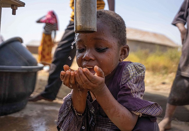 Aziza drinking clean, safe water at a borehole in Nigeria
