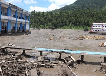 A flood-damaged school beside a plain of mud and debris.